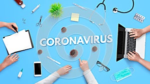 Coronavirus text on hospital desk surrounded by medical equipment and medicines