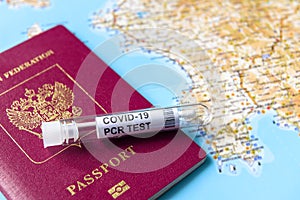 Coronavirus, travel and test concept, tube for COVID-19 PCR testing and passport on tourist map