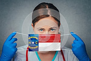 Coronavirus in U.S. State North Carolina, Female Doctor Portrait, protect Face surgical medical mask with North Carolina Flag.