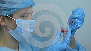 Coronavirus vaccination. Female laborant in protective medical gear holding syringe with preventive medications for injection for