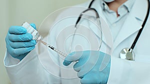 Coronavirus vaccination vial being used by scientist or doctor wiht injection needle. Concept of corona virus treatment