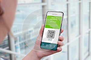Coronavirus vaccinations certified app interface concept with qr code on smart phone in woman hand