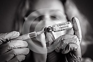 Coronavirus vaccine bottle and syringe in doctorÃ¢â¬â¢s hands photo