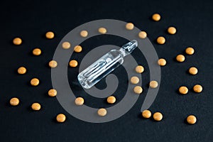 Coronavirus vaccine concept, cure for COVID-19. Pills and ampoule with drug against SARS-CoV-2.
