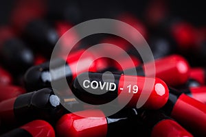 Coronavirus vaccine. Covid-19 Cure. Anti-Covid 19, view a red pill word - COVID-19 with many white pills