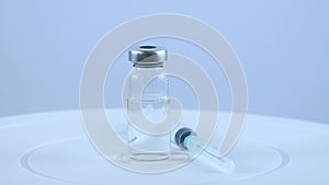 Coronavirus vaccine and medical syringe on white background. Rotation of drugs for injection. The concept of vaccination