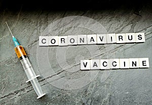 Coronavirus vaccine with syringe on black background