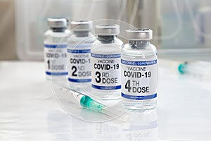 COVID-19 vaccine vials for vaccination labeled with 1st, 2nd, 3rd and 4th doses for booster shot against omicron variants photo