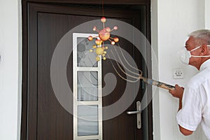 Coronavirus waiting in front of the house, a senior man trying to fight it with a garden fork photo