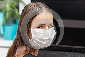 Coronovirus Prevention. Young woman in antibacterial mask at work in the office