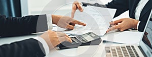 Corporate accountant team use calculator to calculate financial report. Shrewd