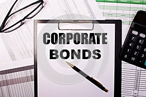 CORPORATE BONDS written on a white piece of paper next to the glasses. reports and calculator. Business concept