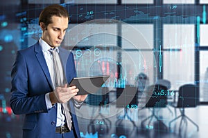 Corporate business and global economy concept with handsome man using digital tablet on virtual screen background with financial