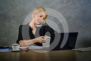 Corporate business portrait of young beautiful and busy woman with blonde hair working at office laptop computer desk talking and