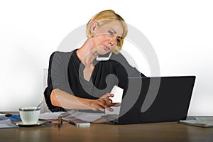 Corporate business portrait of young beautiful and busy woman with blonde hair working at office laptop computer desk talking on m