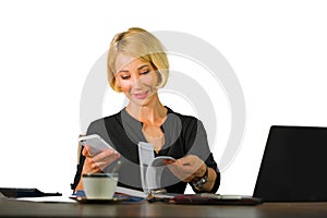 Corporate business portrait of young beautiful and happy woman with blonde hair smiling while working relaxed at office laptop com