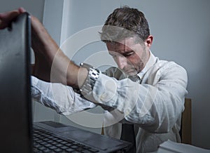 Corporate business work stress - young desperate and frustrated businessman working stressed and overwhelmed at office computer