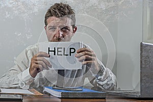 Corporate business worker in stress - young attractive stressed and desperate businessman holding help sign overworked and