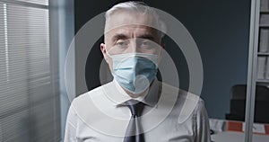 Corporate businessman wearing a surgical mask