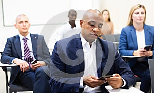 Corporate employees attentively listening to business training in conference room