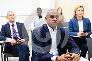 Corporate employees attentively listening to business training in conference room