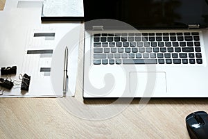 Corporate identity mock up on an desk with laptop and documentation with graphics.