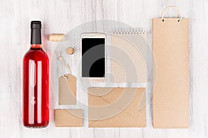 Corporate identity template for wine industry, blank beige kraft packaging, stationery, phone set with bottle rose wine on soft w