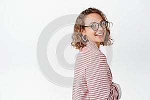 Corporate people. Enthusiastic businesswoman in glasses and suit, turn head at camera and smiling confident, standing