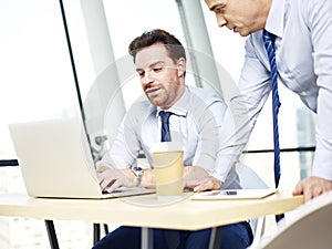 Corporate people working together on laptop computer