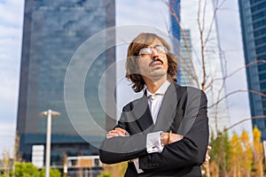 Corporate portrait of an alternative businessman in a business park with arms crossed