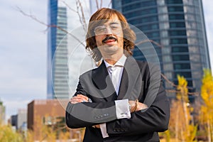 Corporate portrait of an alternative businessman in a business park with arms crossed