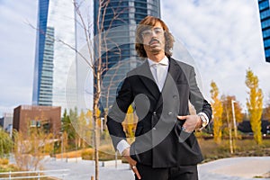 Corporate portrait of an alternative businessman in a business park with hands on his pockets