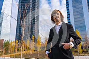 Corporate portrait of an alternative businessman in a business park with hands on his pockets