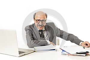 corporate portrait of 60s bald happy business man smiling confident and satisfied sitting at computer laptop office desk working