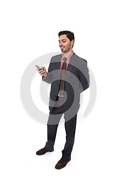 Corporate portrait of young attractive businessman of Latin Hispanic ethnicity smiling using mobile phone