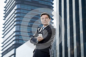 Corporate portrait of young attractive businessman with mobile phone outdoors