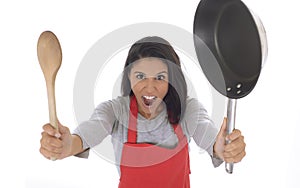 Corporate portrait of young attractive hispanic home cook woman in red apron posing happy and smiling isolated