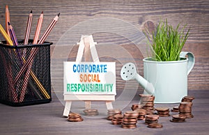 Corporate Social Responsibility Business Concept. Miniature watering pot with fresh green spring grass and small change