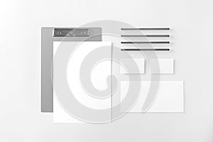 Corporate stationery set mockup. Folder, letterhead, two business cards and envelope at white textured paper background.