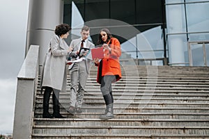 Corporate team of business professionals discussing outside a modern office