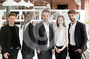 Corporate team of young smiling business people looking at camer