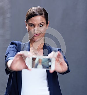 Corporate woman, selfie and cellphone by dark background for happiness, social media and funny face. Confident female