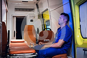 Corpsman in uniform sits inside the ambulance car