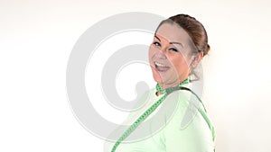 Corpulent woman wrapping a measuring tape around the neck and winking