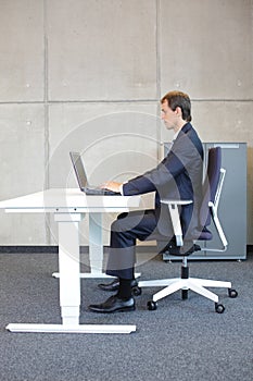 correct sitting position at workstation - man in suit - photo