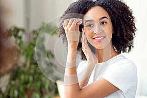 Correcting eyebrows shape in front of mirror and beauty procedure