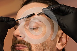Correcting shape of eyebrows to male client