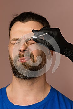 Correcting shape of eyebrows to male client