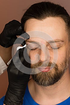 Correcting shape of eyebrows to male client