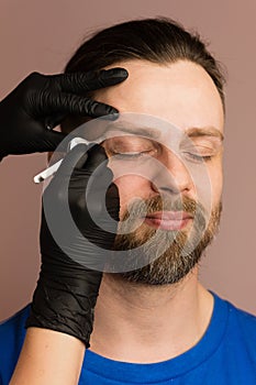 Correcting shape of eyebrows to male client